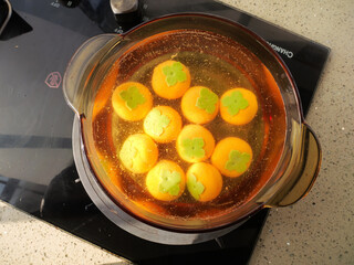 Asian Dumplings Cooking in Clear Broth on Modern Induction Stove Kitchen Preparation