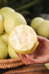 Fresh Cut Guava Fruit Half Showing Soft Creamy White Flesh and Heart-Shaped Seeds in Hand