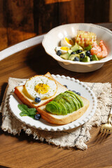 Avocado Toast with Heart-Shaped Egg and Fresh Blueberries Healthy Breakfast on Wooden Table
