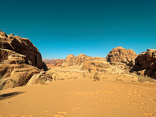 Wadi Rum, Jordan: a stunning red desert wilderness. Towering sandstone mountains, ancient inscriptions, and starry nights await.A red desert wilderness with camels and Bedouin camps