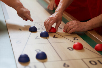 senior Playing the board game of shuffleboard.  Kidult gaming
