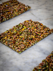 A close-up image of freshly made pistachio brittle at a Sicilian street kitchen.