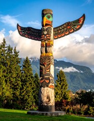 Obraz premium Totem pole against a backdrop of mountains and sky