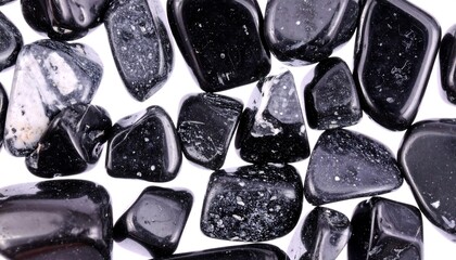 Smooth, black tumbled stones with white flecks, isolated on white