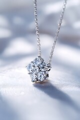 Delicate silver necklace with a cluster of sparkling diamonds on a white, softly lit background.