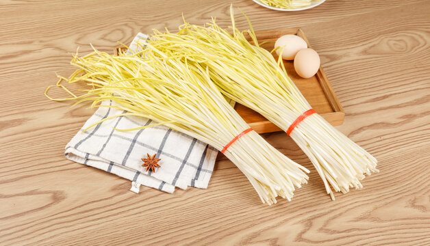 Fresh Yellow Noodles with Eggs on Wooden Kitchen Background