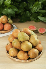 Fresh Guava Fruits in Wicker Basket on Wood Table with Mint Leaves Tropical Food Display
