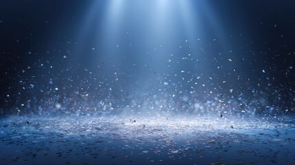 Spotlights illuminate a floor covered in scattered confetti against a dark blue background