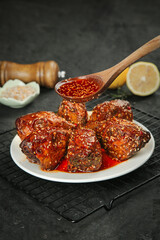 Spicy braised rabbit head with red chili sauce on white plate - traditional comfort food cooking