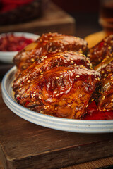 Spicy Glazed Rabbit Head with Marinade and Sesame Seeds on Rustic Wooden Table