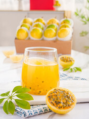 Fresh Golden Passion Fruit Juice with Whole Fruits from Hainan China on White Wooden Background