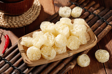 Dried Lotus Root Slices in Bamboo Basket - Asian Cooking Ingredient with Traditional Wooden Background