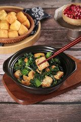 Asian Stir-Fried Tofu with Green Vegetables and Chopsticks on Wooden Table