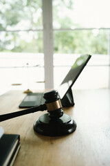 A judge's gavel placed on a wooden desk beside a laptop, symbolizing law, justice, court decisions, and legal proceedings in a modern office.