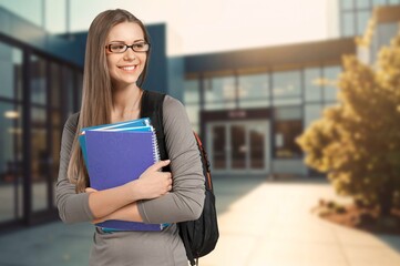 A young happy woman student holds notebooks