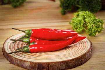 Fresh Red Chili Peppers on Wooden Board with Herbs - Spicy Cooking Ingredients