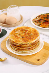 Stack of Golden Scallion Pancakes with Traditional Asian Food on Wooden Board