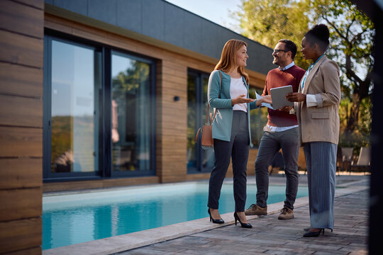 Happy black real estate agent talking to her client during open house day. - Powered by Adobe