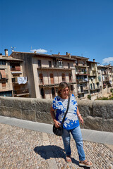 Fototapeta premium A mature woman on vacation in Valderrobres, Teruel, connecting with the history and serenity of the rural Mediterranean environment