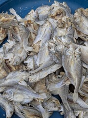 A close-up overhead view of a pile of dried fish, likely for sale at a market.