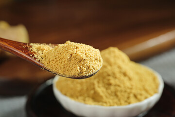 Golden turmeric powder on wooden spoon - natural healthy spice and seasoning ingredient