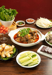 Asian Hot Pot Feast with Beef Stew and Fresh Vegetables on Wooden Table
