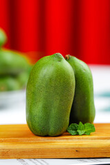 Fresh Green Papaya Fruit on Wooden Board with Mint Leaves for Healthy Cooking