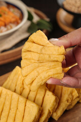 Hand Holding Dried Tofu Skin Strips - Traditional Asian Cooking Ingredient