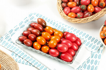 Fresh Mixed Tricolor Cherry Tomatoes Assortment on White Plate and Wicker Basket