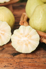 Fresh Picked Guava Fruit Sliced Open Showing Cream Colored Soft Centered Flesh on Wooden Table