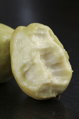 Fresh Guava Fruit Cut in Half Showing White Creamy Flesh on Dark Background