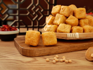 Traditional Asian Fried Tofu Puffs on Bamboo Steamer with Wooden Cutting Board and Soybeans