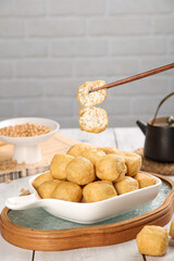 Golden Bean Curd Puffs with Chopsticks - Traditional Asian Fried Tofu Snack in White Bowl