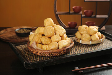 Golden Fried Tofu Puffs in Woven Basket on Traditional Wooden Serving Tray