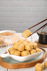 Golden Fried Tofu Puffs with Chopsticks - Asian Cuisine Ready to Eat
