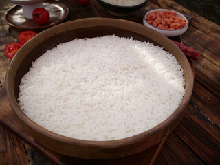 Hot Fragrant Thai Rice Grains in Traditional Wooden Pot with Fresh Vegetables