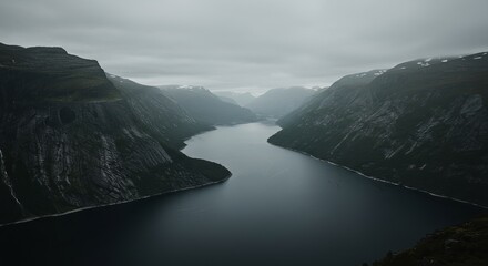 Dramatic fjord landscape with dark moody water and lush green mountains