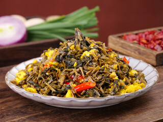 Traditional Shaoxing Chinese Stir-Fried Vegetables with Scrambled Eggs and Dried Plums on Wooden Kitchen Table