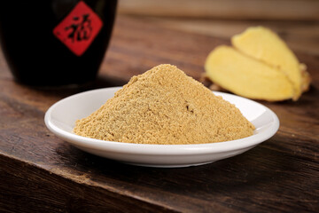 Fresh Ginger Powder with Whole Ginger Root and Asian Condiments on Rustic Wooden Table