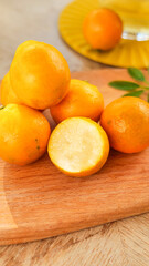 Fresh Kumquats on Wooden Board with Sliced Fruit Showing Sweet Interior