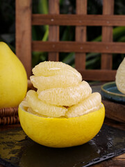 Fresh Pomelo Citrus Fruit Peeled and Segmented with Juicy White Flesh in Natural Garden Setting