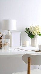White minimalist desk with lamp, frame, and flowers