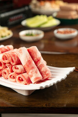 Raw Lamb Strips with Hot Pot Ingredients and Golden Cucumber Sides for Korean BBQ Cooking