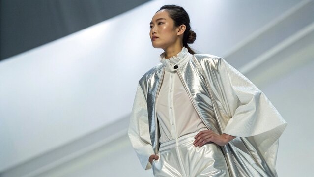 Asian Woman in Futuristic Fashion with White Silk and Silver Metallic Outfit for Modern Style Concept