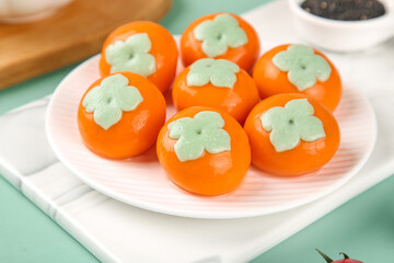 Fresh Persimmon Fruits on White Plate - Perfect for New Year Eve Celebrations and Holiday Food Photography