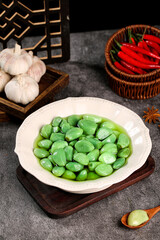 Emerald Green Pickled Vegetables with Garlic and Chili Peppers on Dark Slate Background