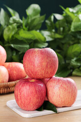 Fresh Red Fuji Apples from Shandong Luochuan Region on White Cutting Board with Green Leaves