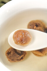 Dried Longan Fruit on White Spoon - Traditional Cantonese Sweet Preserved Delicacy