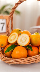 Fresh Sweet Kumquats with Smooth Skin in Wicker Basket - Small Citrus Fruits Cut and Whole