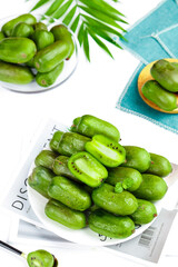 Fresh Mini Kiwifruit and Jujube Fruits with Palm Leaves on White Background